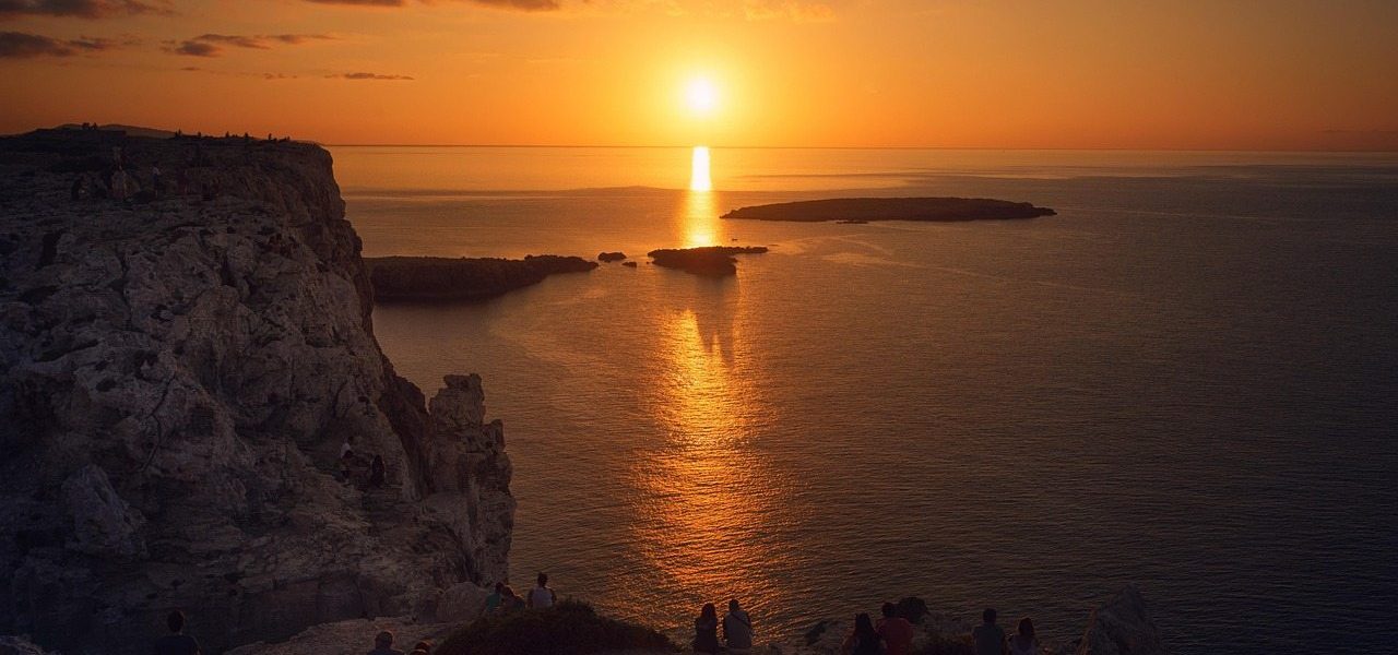 Farbintensiver Sonennuntergang vor Menorca mit Zuschauern Farbintensiver Sonennuntergang vor Menorca mit Zuschauern